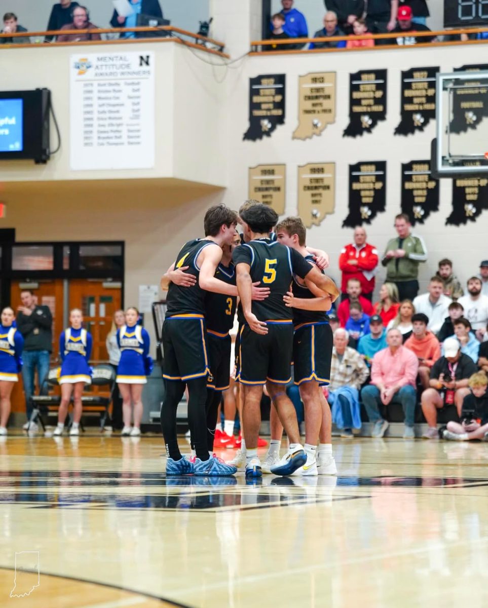 Carmel players huddle up during a stoppage of play. Image Credit: Carmel Basketball Instagram.